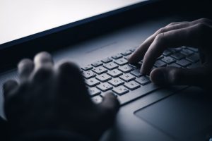 hands dark keyboard laptop computer suspicious malicious bad fraud digital screen glow